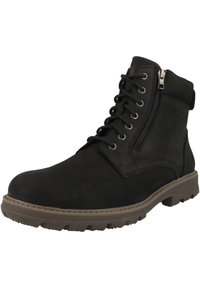 Botín de cuero negro hasta el tobillo con cordones y cierre lateral con cremallera. Presenta un upper texturizado, suela de goma y cuello acolchado para mayor comodidad.