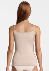 Beige tank top with thin straps, fitted design, soft texture, and simple hem. Smooth material without visible patterns or hardware details.