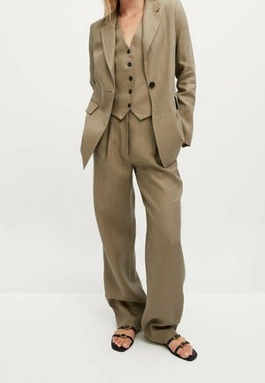 Khaki three-piece suit featuring a fitted jacket, waistcoat, and wide-leg trousers, made of a lightweight fabric with a smooth texture; paired with black sandals.