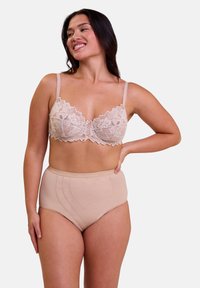 Soutien-gorge en dentelle avec un bord festonné et des fronces au centre en beige clair, associé à un slip taille haute comportant des motifs de cœurs brodés de la même couleur.