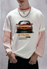 Hvid kortærmet t-shirt med et trykt Honda Civic SiR grafik, lagd over en langærmet stribet skjorte. Casual fit, blødt stof.