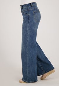 Wijduitlopende jeans in middelblauwe denim, met een hoge taille, klassiek vijf-pocket ontwerp en een rechte snit. De randen zijn netjes gestikt.