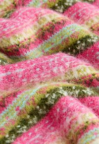 Gewebter Stoff in Pink, Grün und Weiß mit einer strukturierten Oberfläche. Verfügt über ein mehrfarbiges Muster und eine flauschige, weiche Erscheinung.