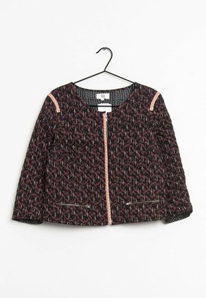 Veste à motifs noirs et roses avec une fermeture éclair frontale, deux poches zippées et une bordure rose sur les épaules, présentée sur un cintre.