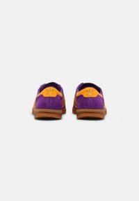 Purple suede shoes with orange accents, featuring a breathable mesh upper, a rounded toe, and a rubber sole with textured grip.