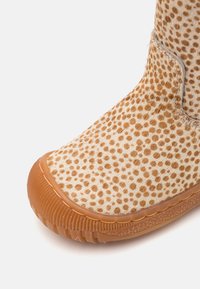 Bottine à cheville marron à pois, fabriquée en matériau texturé avec une semelle en caoutchouc, dotée d'un bout rond et de détails de couture discrets.