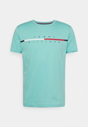 Hellblaues kurzärmeliges T-Shirt mit dem Schriftzug "Tommy Hilfiger" und einem horizontalen Streifen in Schwarz, Weiß und Rot über der Brust.