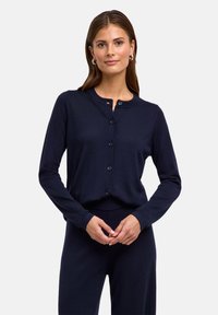 Navyblauer Cardigan aus einem weichen Stoff, mit Rundhalsausschnitt, langen Ärmeln und einem Knopfverschluss vorne.