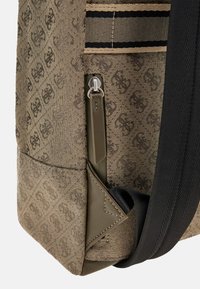 Borsa in tessuto marrone con motivo, tasca con zip, tracolla nera e dettagli lisci in verde oliva. Superficie testurizzata con rinforzo del logo.