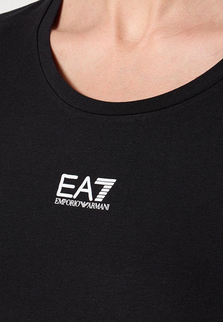 Czarna dopasowana koszulka z okrągłym dekoltem. Posiada haftowane na piersi białe logo EA7, wykonana z gładkiego, teksturowanego materiału.