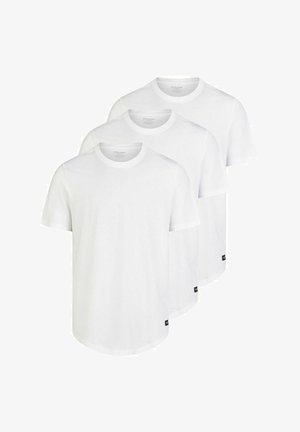Tres camisetas de algodón blancas apiladas. Cada una tiene un escote redondo, mangas cortas y un pequeño logotipo negro en el dobladillo. Textura suave.