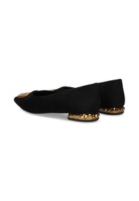 Bailarinas de ante negro con punta afilada, que presentan un acento dorado en la punta y un borde dorado adornado con joyas en el tacón.