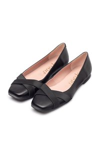 Scarpe nere piatte con punta quadrata e design a frangia incrociata. Realizzate in pelle liscia, con una leggera fodera rosa e una suola flessibile.