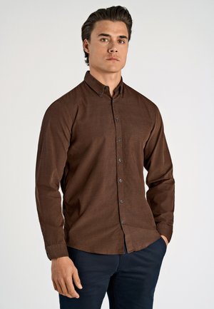 Bruine langemouwen blouse met een button-down kraag, voorzien van donkere knopen, een subtiele textuur en een getailleerde pasvorm, gecombineerd met donkere broeken.