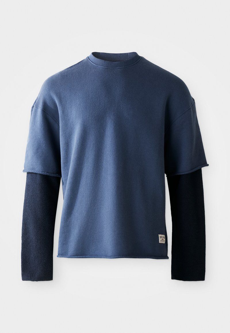 Navy blue sweatshirt with short sleeves, featuring a contrasting long dark blue sleeve underneath. Made of soft fabric, minimalistic design.