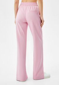 Pink wide-leg trousers made of soft fabric, featuring an elastic waistband and a single back pocket. Accents include a clean hem.
