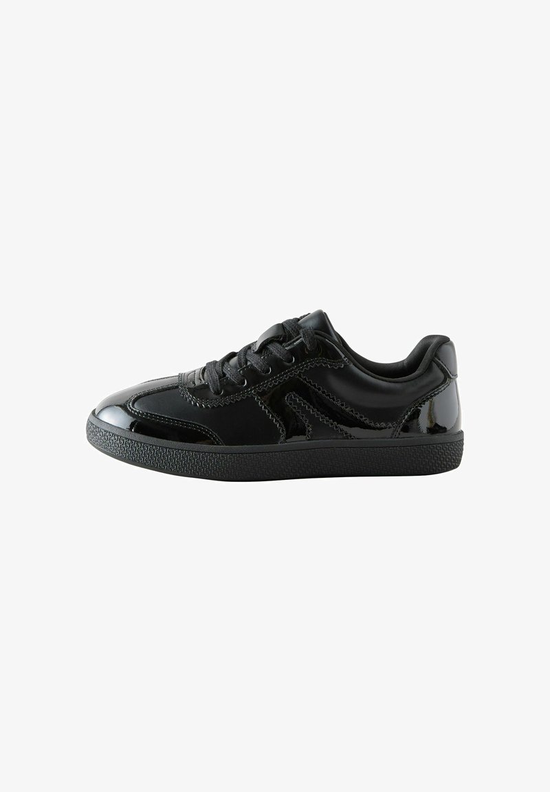 Baskets basses noires avec des accents brillants, une semelle texturée et des lacets noirs sur fond blanc.