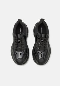 Svarta sneakers gjorda av läder och mesh, med en blank yta, snörningsdesign, vadderad krage och texturerad gummisula.