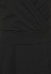 Černé zavinovací šaty s hladkou strukturou, disponující vypasovaným pasem a jemným nařasením. Tkanina vypadá lehce a elegantně splývá.