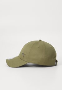 Olive green baseball cap with a curved brim, featuring a silver logo accent, stitched eyelets, and a tag on the side.