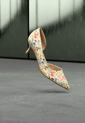 Chaussure à talon haut à motif floral, présentant un bout pointu, un fond crème et un talon élancé. Texture lisse avec des accents décoratifs.