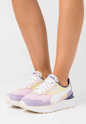 Sneakers viola e pastello in mesh e suede, con lacci bianchi, suola spessa e un accento blu scuro a contrasto.