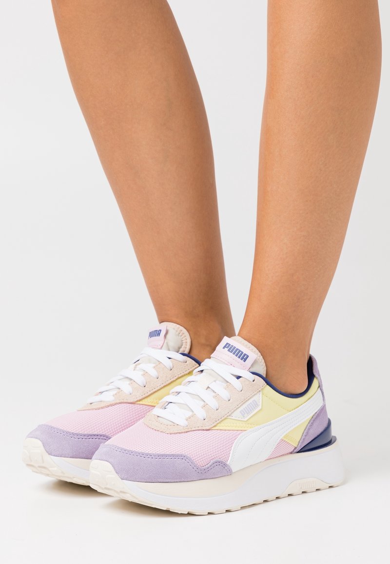 Baskets violettes et pastel en mesh et daim, avec des lacets blancs, une semelle épaisse et un accent bleu foncé contrastant.