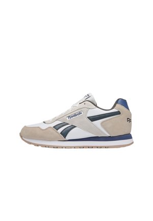 Reebok lage sneaker in wit en beige suède met marineblauwe accenten, witte veters en merklogo's op de zijkant en hiel.