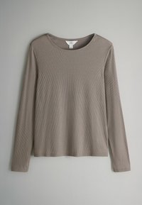 Långärmad, ribbad topp i en taupefärg. Rund halsringning utan knäppningar. Mjuk textur och avslappnad passform. Lättviktig tyg med stretch.