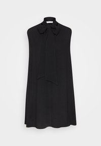 Svart ärmlös klänning med hög halsringning och stor rosettdekoration vid kragen. Tyget har en slät, något texturerad yta.