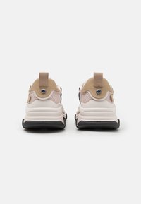 Men's sneakers with a black and beige design, mesh fabric upper, padded collar, and a textured rubber sole. Includes pull tab at the heel.