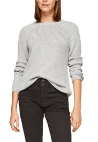 Grauer gestrickter Pullover mit lockerem Sitz, geripptem Saum und langen Ärmeln. Kombiniert mit einer schwarzen Hose und einem abgerundeten Ausschnitt.