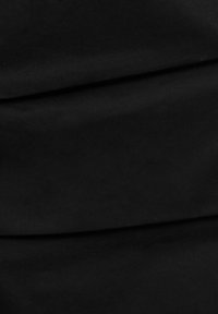 Tissu noir avec des plis doux et une texture subtile, mettant en valeur un matériau lisse et un drapé délicat.