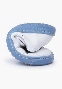 Weißes Leder-Schuhwerk mit einer blauen Gummisohle, das ein rundes Design, Steppdetails und eine weiche Textur aufweist. Gefaltet, um die Flexibilität zu zeigen.