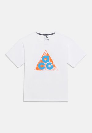 Hvid T-shirt med korte ærmer og et slidt orange trekant på forsiden, indeholdende store blå bogstaver "a", "c" og "g".