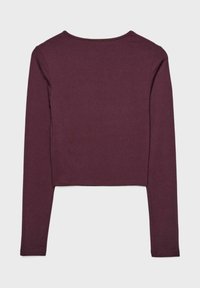 Top corto a maniche lunghe color bordeaux in tessuto morbido, con scollatura rotonda e cuciture semplici lungo i bordi. Senza fantasie o dettagli.