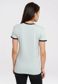 Light green short-sleeve t-shirt with navy blue trim around the collar and sleeves. Soft, smooth texture, fitted design, and rounded hem.