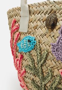 Flettet stråtaske med farverige broderede motiver af havliv og koraller. Inkluderer en dekorativ accent af skaller i messing. Håndtagene er i beige læder.