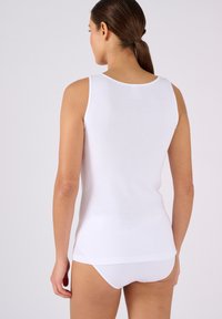 Witte katoenen tanktop met een ronde halslijn, voorzien van een fitted ontwerp en een gladde textuur, gezien van de achterkant, gecombineerd met witte onderkleding.