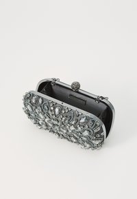 Schwarze Clutch-Tasche mit komplexen silbernen Perlen- und Strassverzierungen, ausgestattet mit einem ovalen Verschluss und einem glänzenden Metallrahmen.