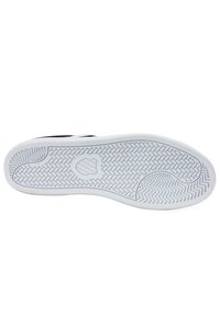 Suela de zapato con un diseño de goma blanca texturizada que presenta patrones de zigzag, un área circular suave y una impresión de logo en el centro.