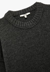 Pull en maille gris foncé avec col rond côtelé et étiquette de marque visible à l'intérieur du col.