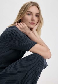 Strickkleid in Dunkelblau mit einem strukturierten Muster. Kurze Ärmel und eine lockere Passform, mit einem runden Halsausschnitt und gerippten Akzenten.