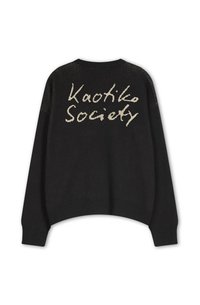 Crna pletena bluza s okruglim izrezom i skraćenim dizajnom. Na leđima je natpis "Kaotiko Society" u svijetloj krem boji. Rebrasti rub i manšete.