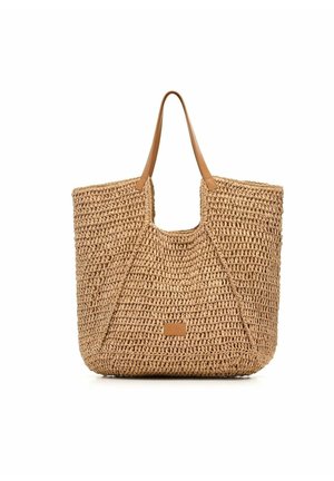 Tkana torebka ze słomy z jasnobrązowymi skórzanymi rączkami i małą prostokątną naszywką z logo na środku przodu.
