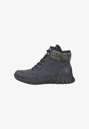 Botas de tobillo de color azul oscuro con un cuello de punto texturizado, que presentan cordones negros y una suela de goma resistente con patrones de huella prominentes.