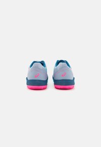 Des chaussures de sport grises et bleues avec une tige texturée, une semelle rose et des accents réfléchissants, conçues pour la performance et la stabilité.