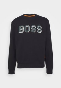 Sudadera negra con el logo "BOSS" en estilo pixelado en blanco y teal. Con puños y dobladillo acanalados, y cuello redondo. Presenta un acento naranja en el cuello.