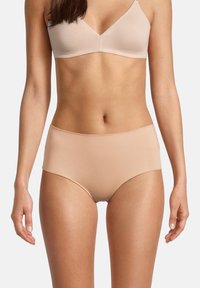 Slip a vita alta beige realizzato in un materiale morbido, caratterizzato da un design senza cuciture e senza elastico visibile in vita o sulle gambe.