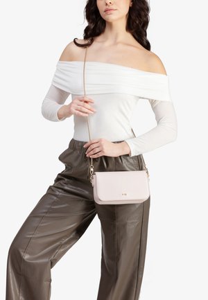 Borsa a tracolla rosa chiaro realizzata in pelle liscia con una tracolla in catena dorata. Presenta una forma rettangolare e un logo in rilievo sottile.